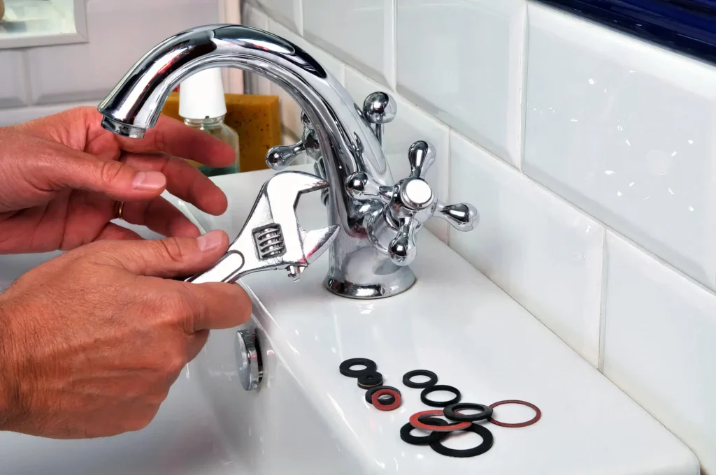 Plumber performing maintenance on a bathroom faucet in Wellington