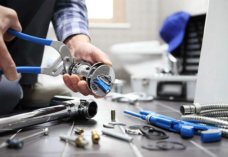 Technician repairing a plumbing fixture with professional tools in Wellington