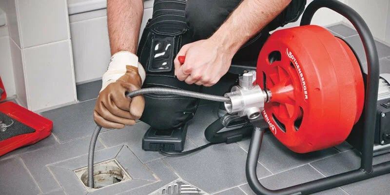 Plumber using a drain-cleaning machine in Wellington