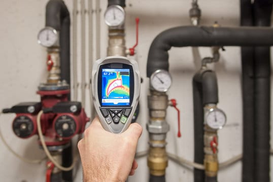 Plumber using a thermal imaging camera to inspect pipes in Wellington