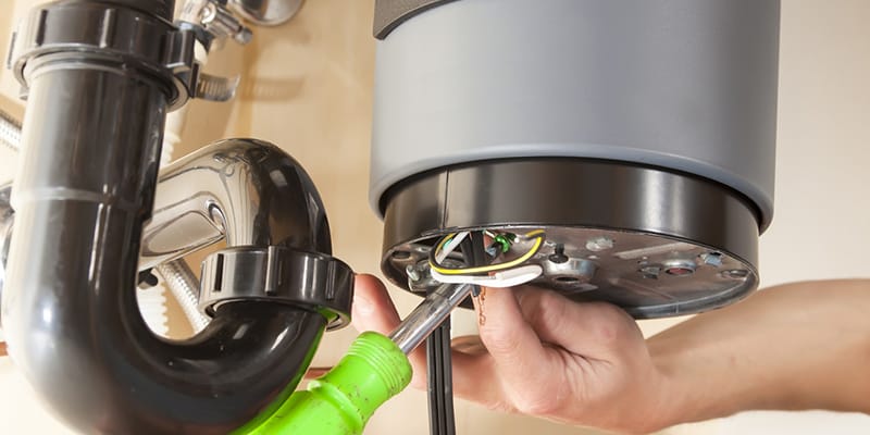 Technician repairing the heating element of a water heater in Wellington