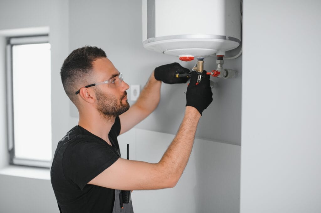 Technician performing water heater maintenance in Wellington