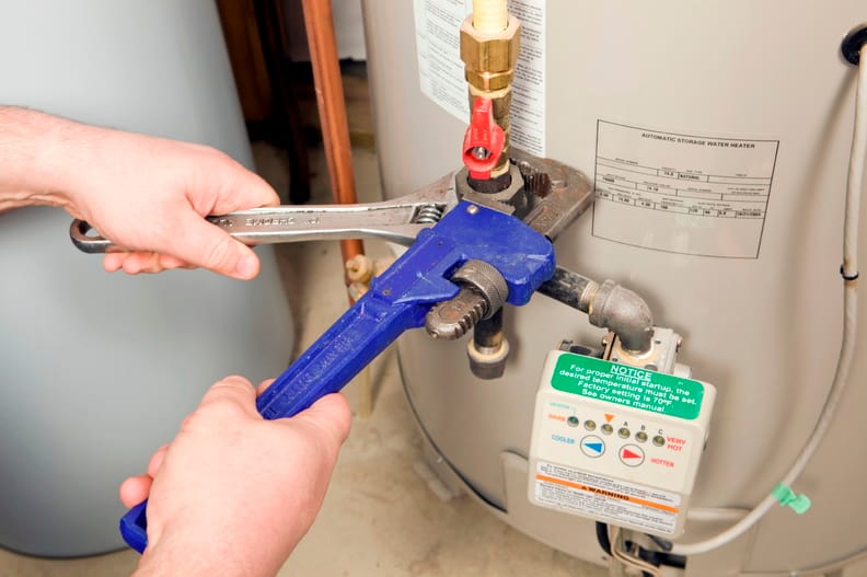 Plumber repairing a water heater valve in Wellington